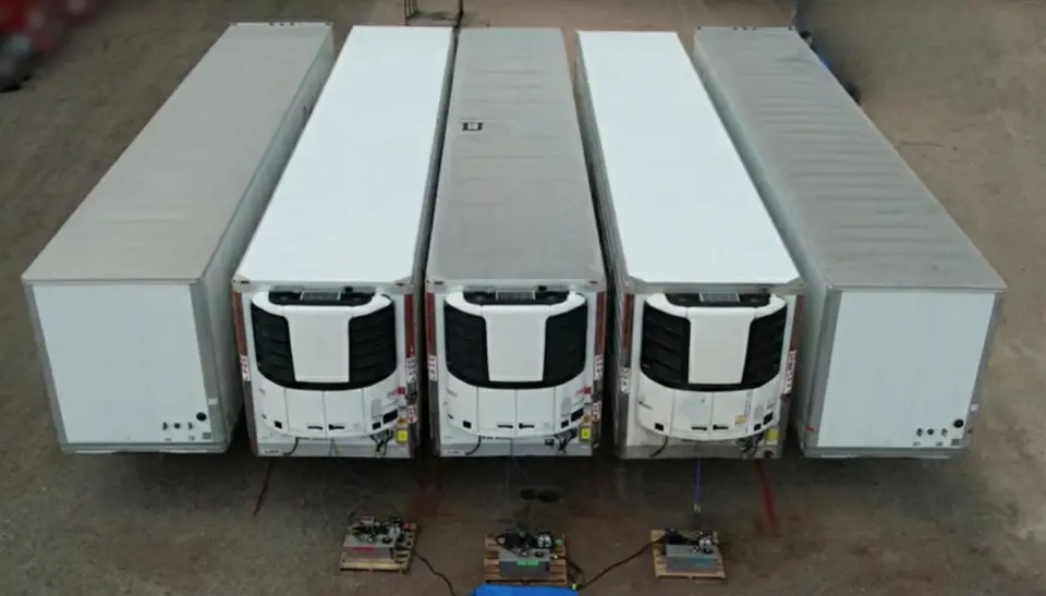 Aerial view of refrigerated trailers comparing Polyfrost coated roofs and bare aluminum roofs.